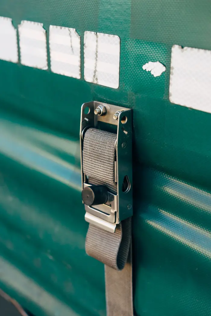 A ratchet strap buckle securing a load on a trailer