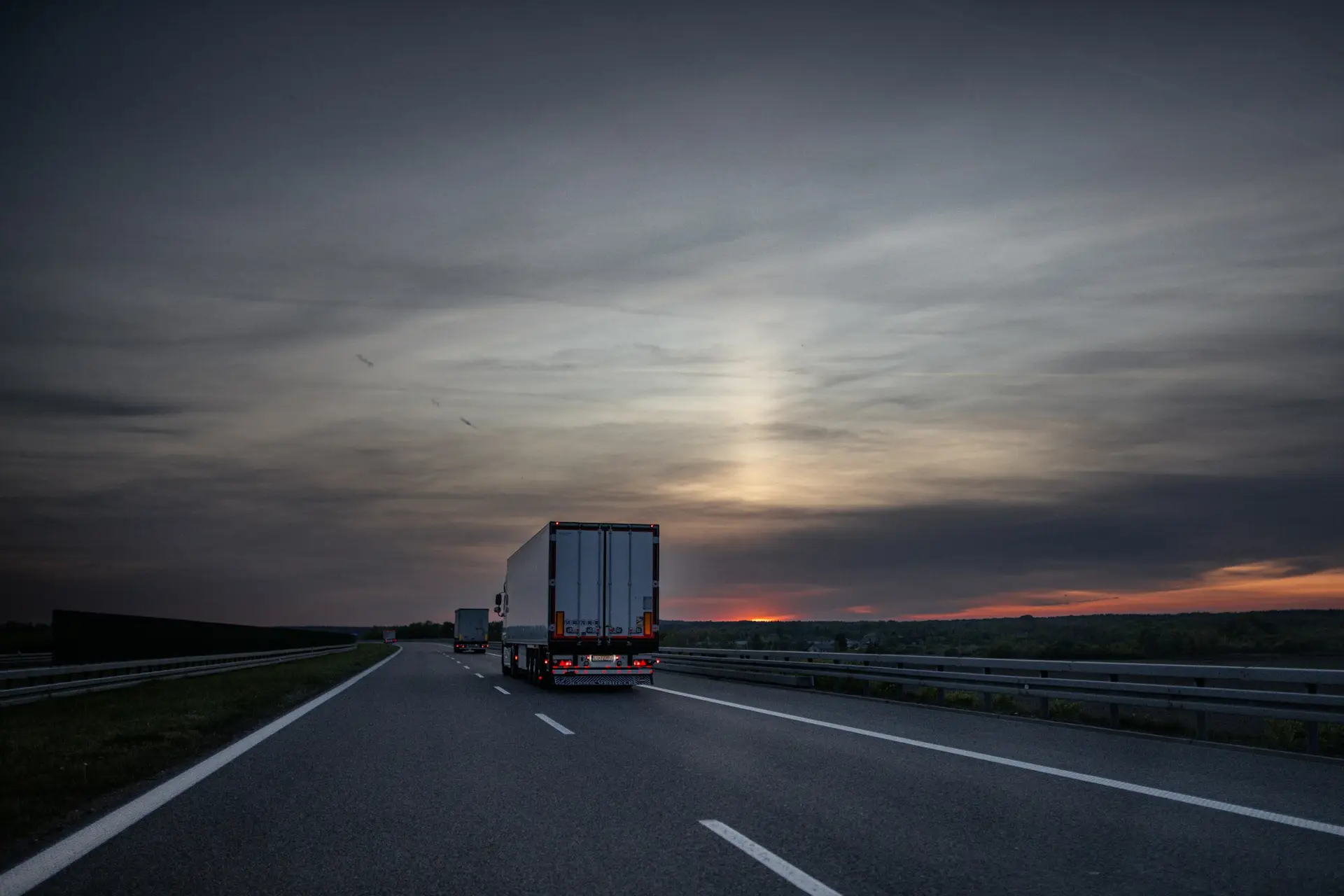 Freight trucks on a highway at dusk